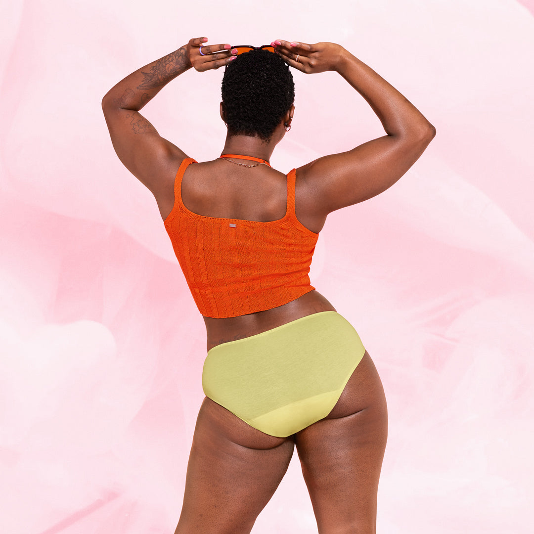 Henkilö esittelee ComfortFit Essentials Hipster runsas vuoto -kuukautisalushousuja.