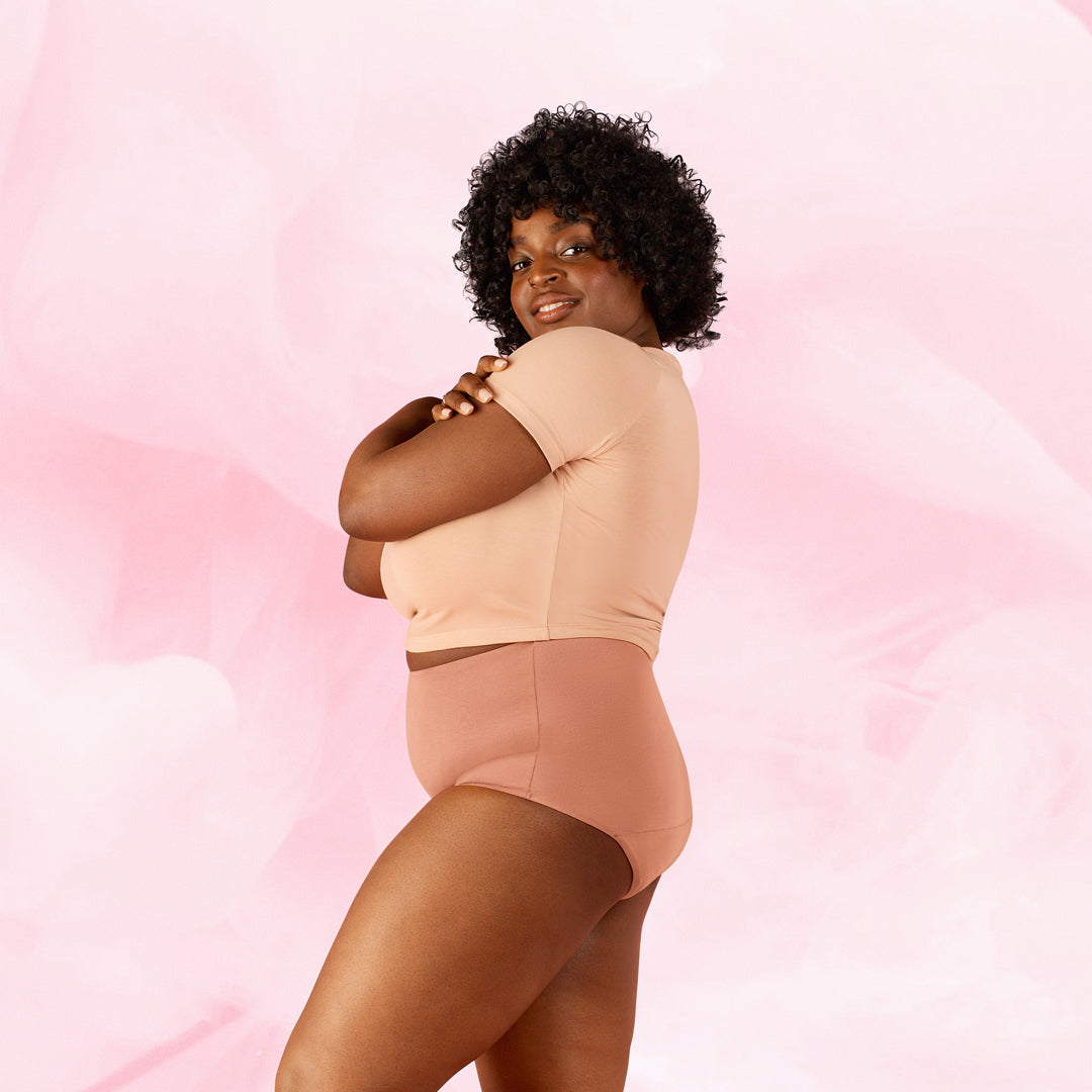 Plus-kokoinen nainen Premium Comfort High Waist Kohtalainen Vuoto Kuukautisalushousut päällä.