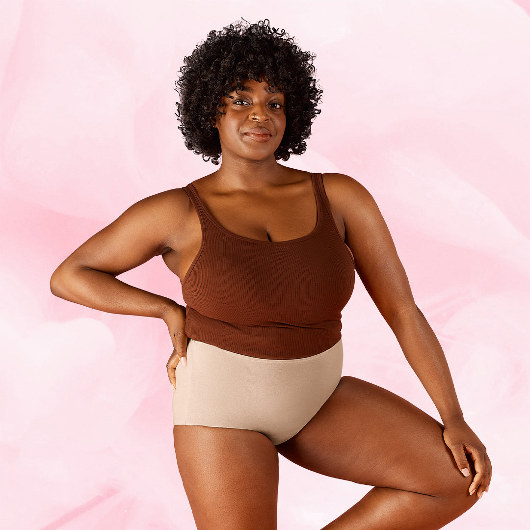 Nuori nainen esittelee Premium Comfort High Waist Kohtalainen Vuoto Kuukautisalushousut.