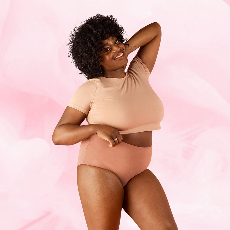 Nainen esittelee Premium Comfort High Waist Kohtalainen Vuoto Kuukautisalushousut.