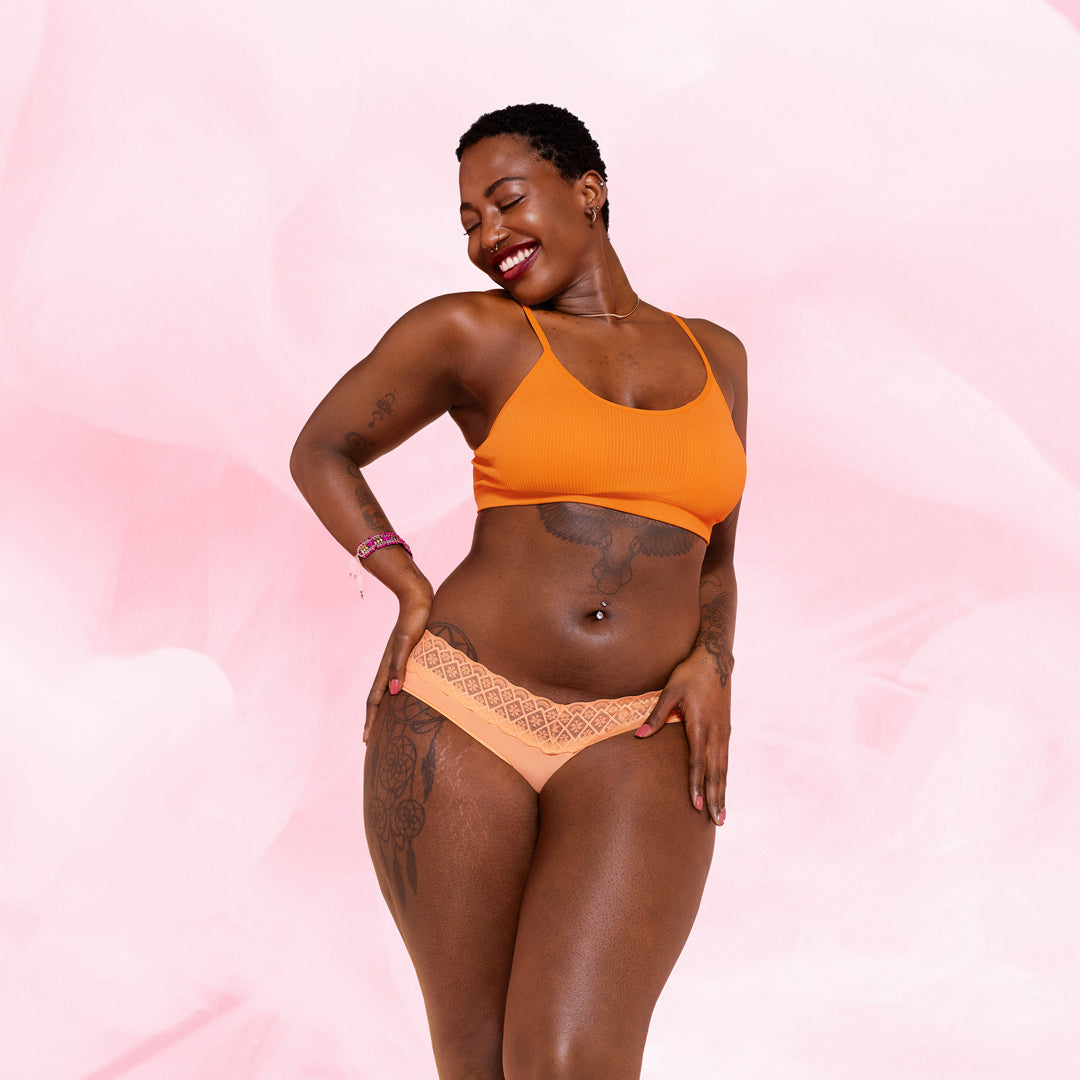 Henkilö esittelee Brazilian Niukka Vuoto Kuukautisalushousut itsevarmasti.