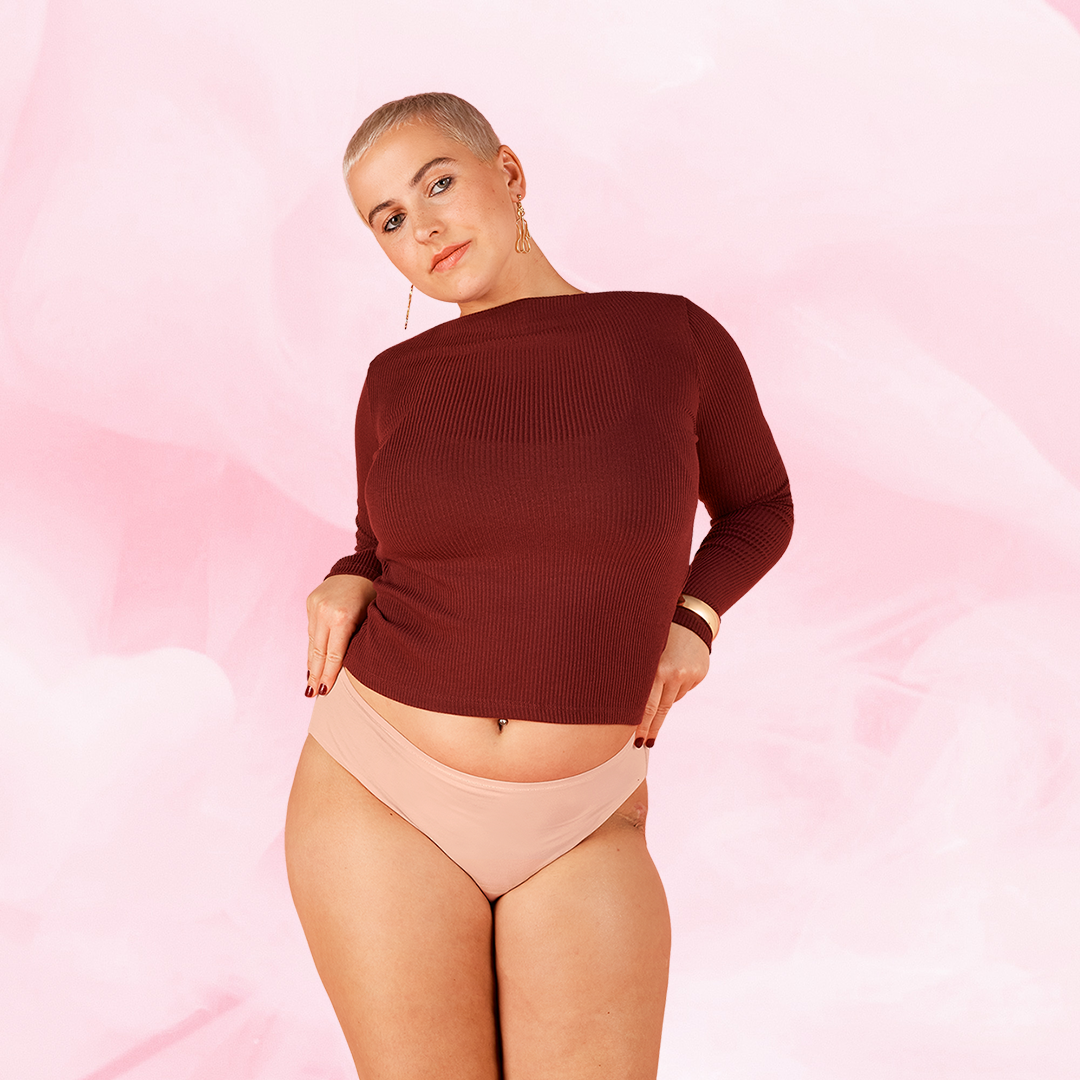 Henkilö esittelee ComfortFit Essentials Brazilian kohtalainen vuoto -kuukautisalushousuja.