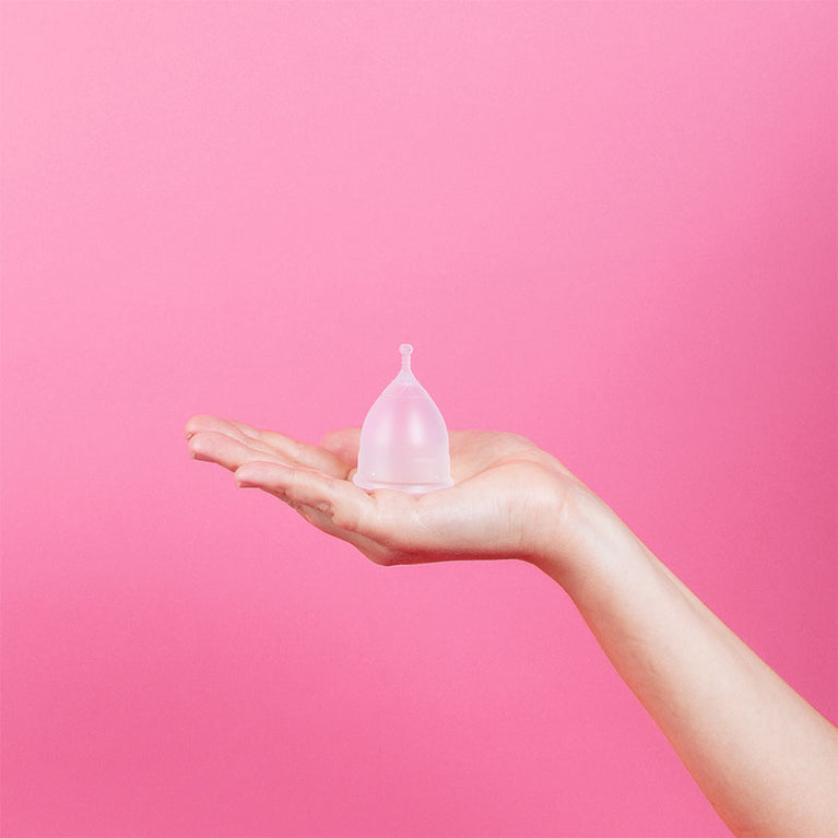 Kuukautiskuppi kädessä, valmistettu lääketieteellisestä silikonista.